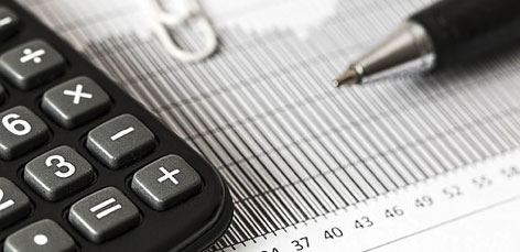 a imagem contém uma caneta e uma calculadora, demonstrando como uma contabilidade para negócsio digitias pode ajudar e ter controle financeiro